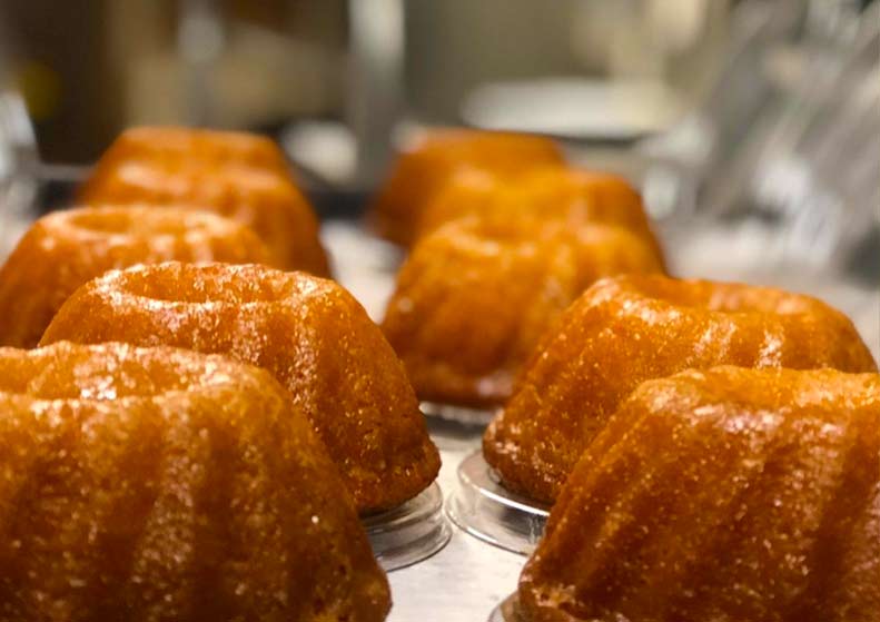 Row of small Bundt cakes on a metal tray with a blurred background