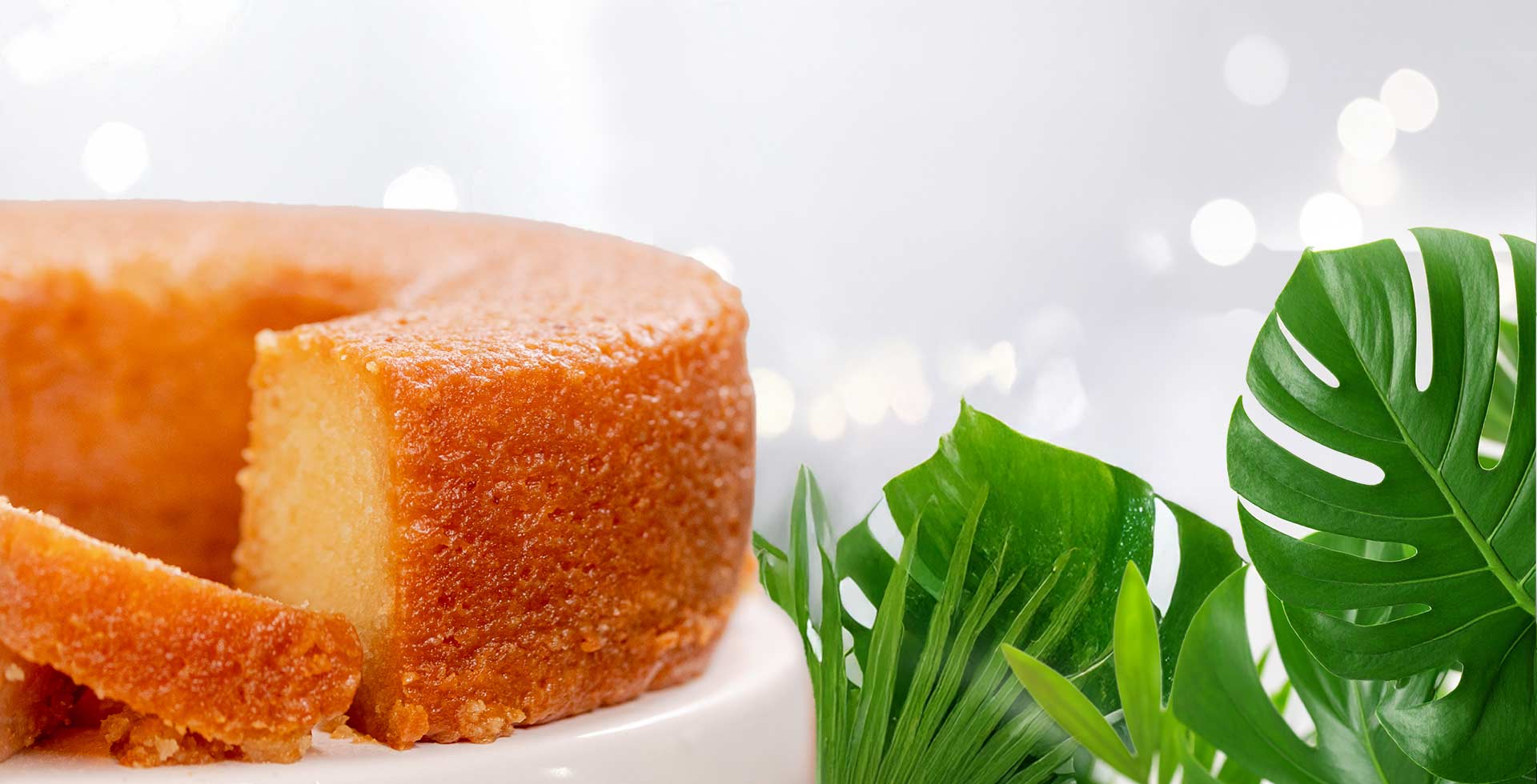 Sliced cake with green leaves on a white background
