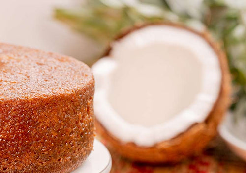Coconut rum cake with a coconut shell on a blurred background