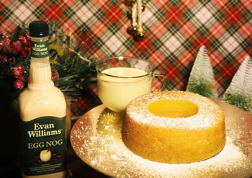 Evan Williams Egg Nog bottle with a cake and cup on a festive background