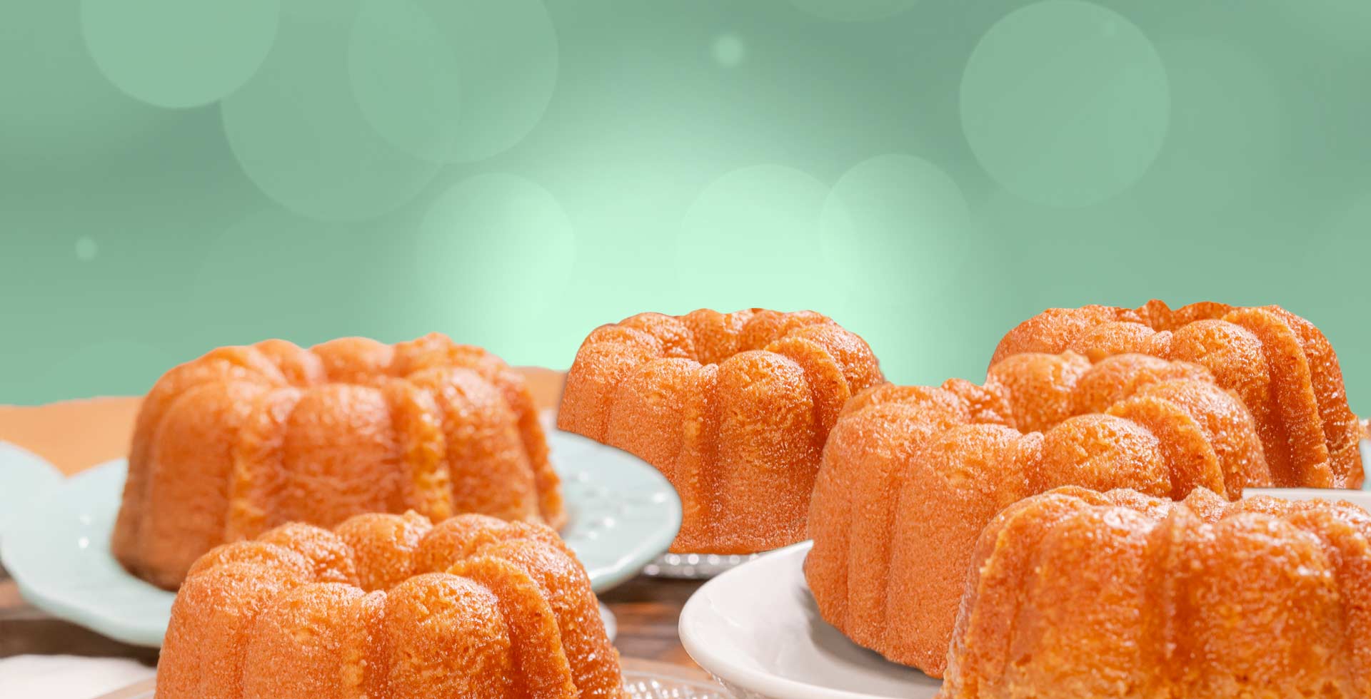 Bundt cakes on a wooden table with a green blurred background