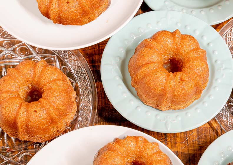 Small bundt cakes on decorative plates on a wooden surface