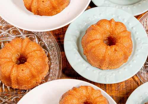 Small bundt cakes on decorative plates on a wooden surface