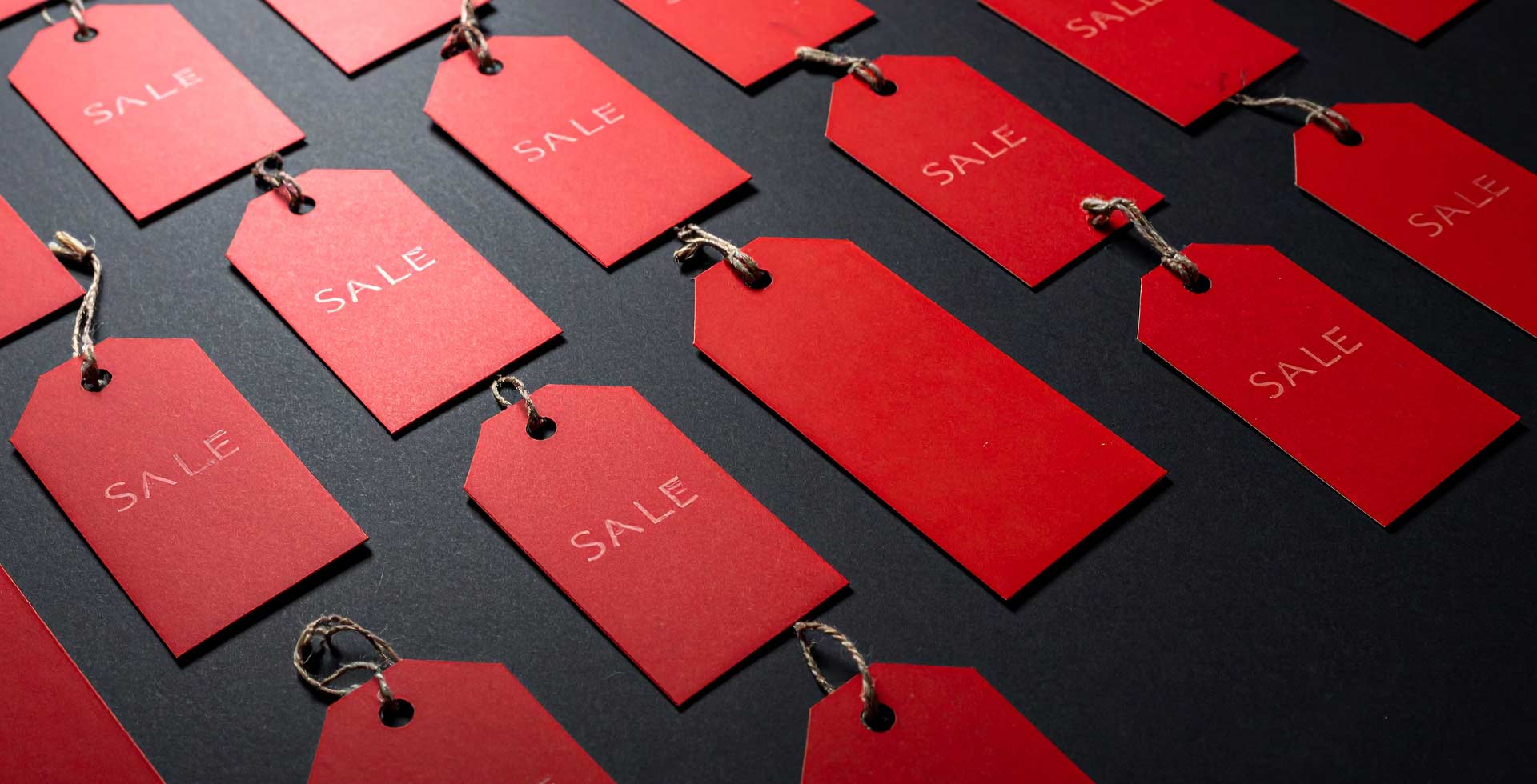 Red 'SALE' tags on a dark background